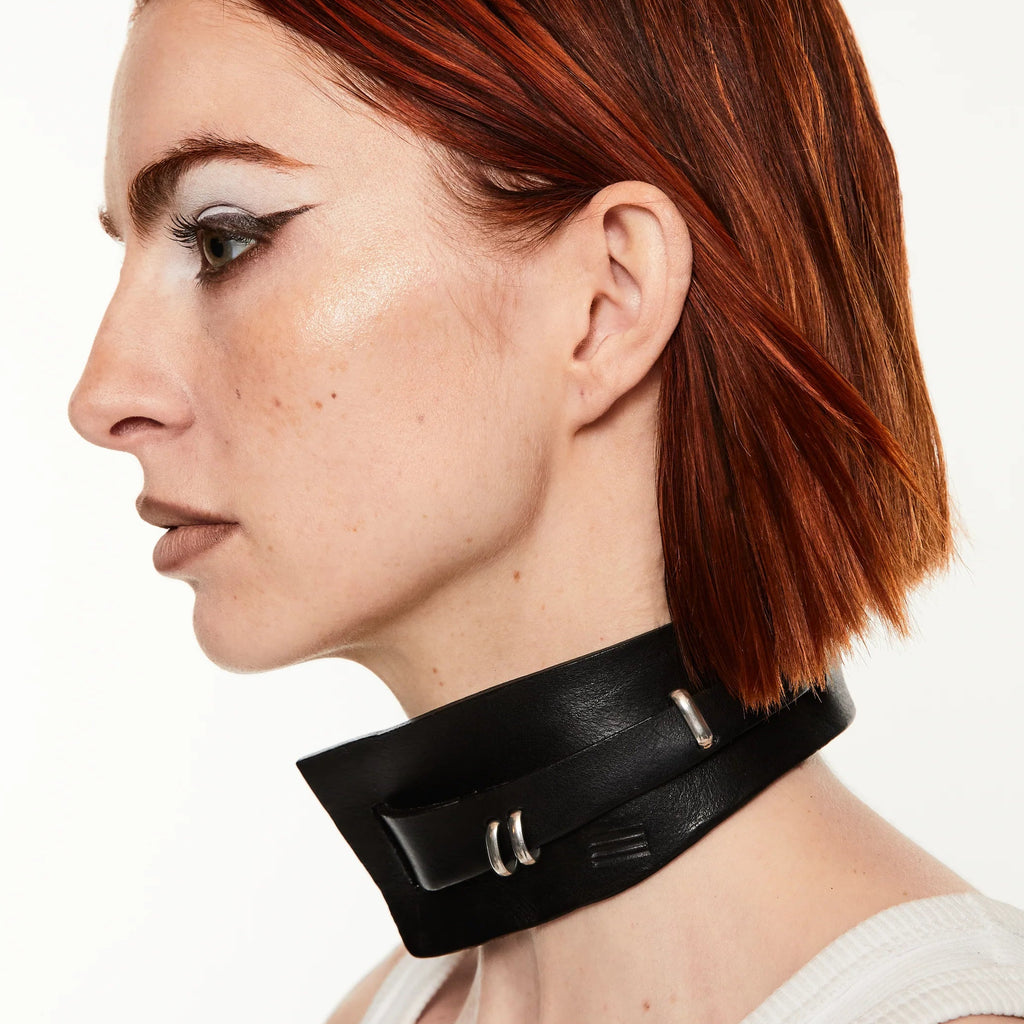 Woman wearing a black leather collar on a white background